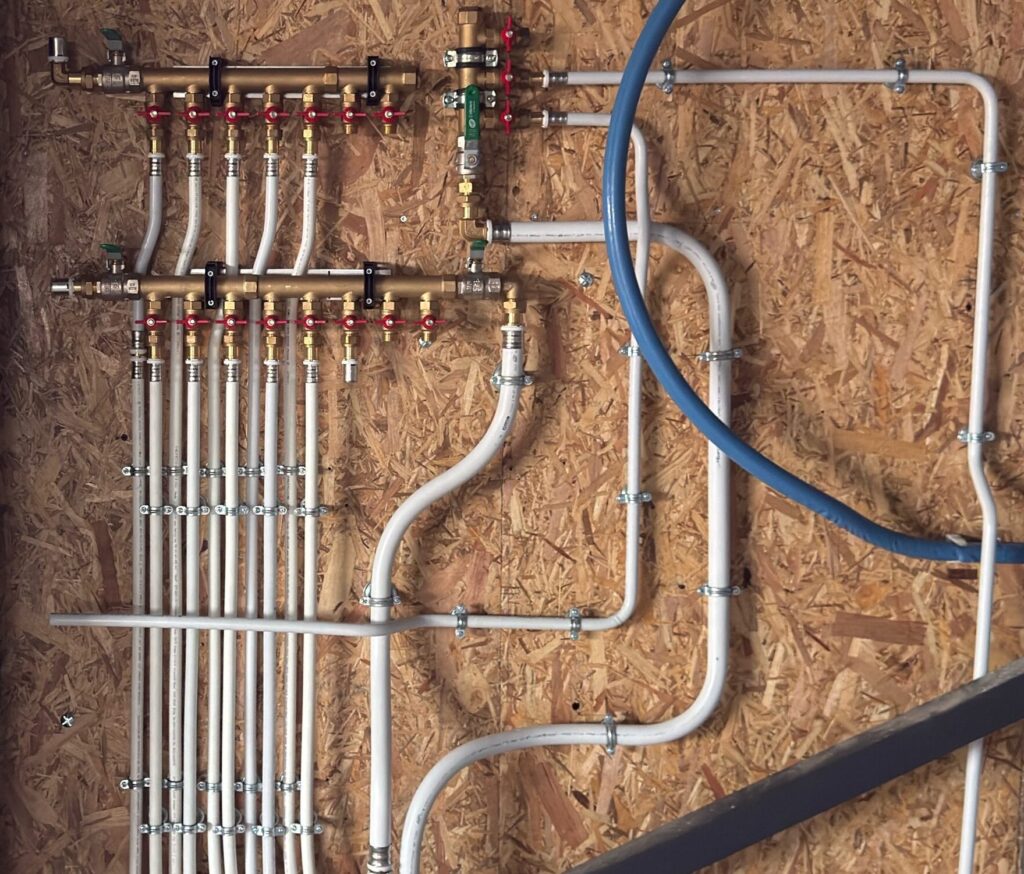Installation de nourrices de distribution d'eau avec vannes individuelles et réseau de tuyauteries multicouches fixé au mur