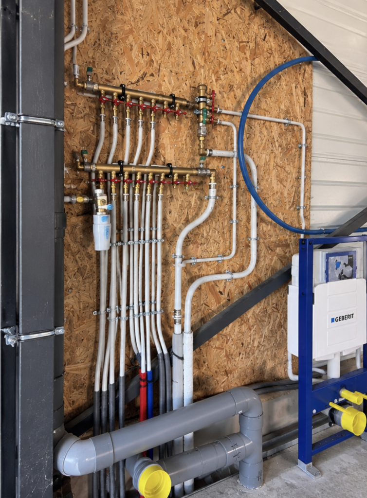 Installation de nourrices de distribution d'eau avec vannes individuelles et réseau de tuyauteries multicouches fixé au mur