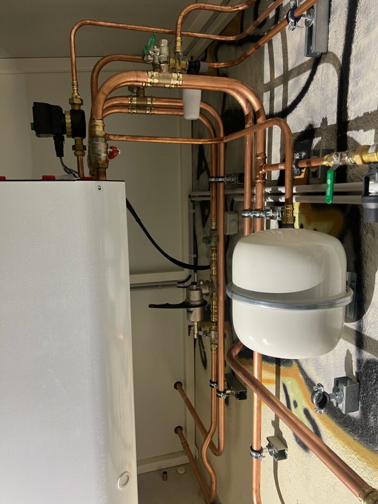 Installation d'un vase d'expansion et raccordements en cuivre dans un local technique de chauffage