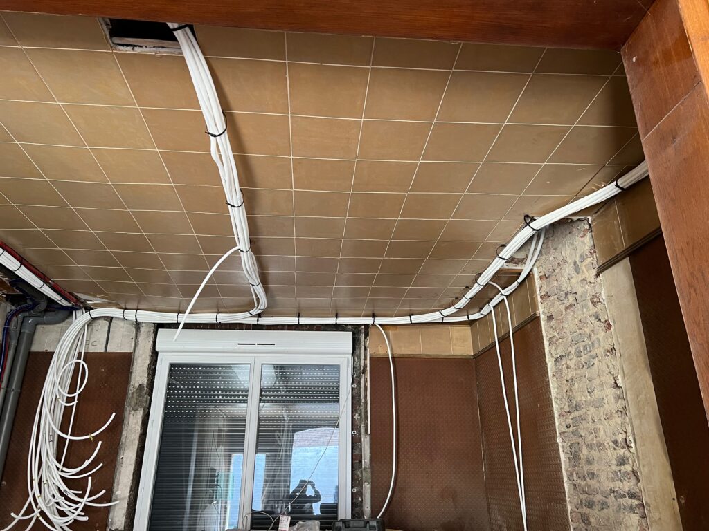Distribution des gaines électriques au plafond lors de la rénovation d’une maison à Lens