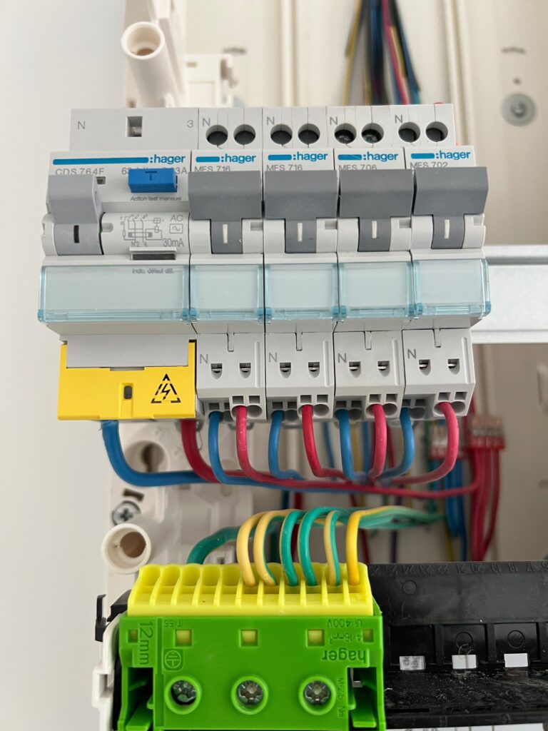 Détail des disjoncteurs et du câblage dans un tableau électrique en cours de montage.