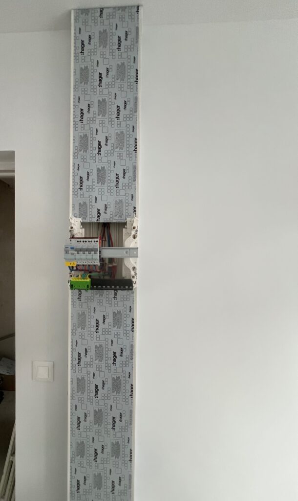 Tableau électrique en cours de câblage, avec les conducteurs et protections visibles.