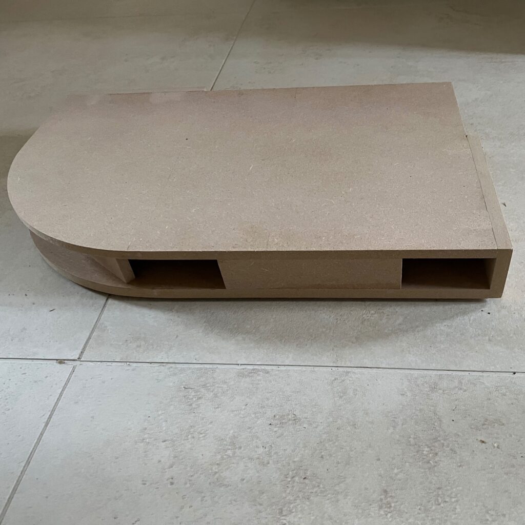 Détail d'un élément cintré en MDF destiné à la réalisation d'un meuble sur mesure ici la plinthe