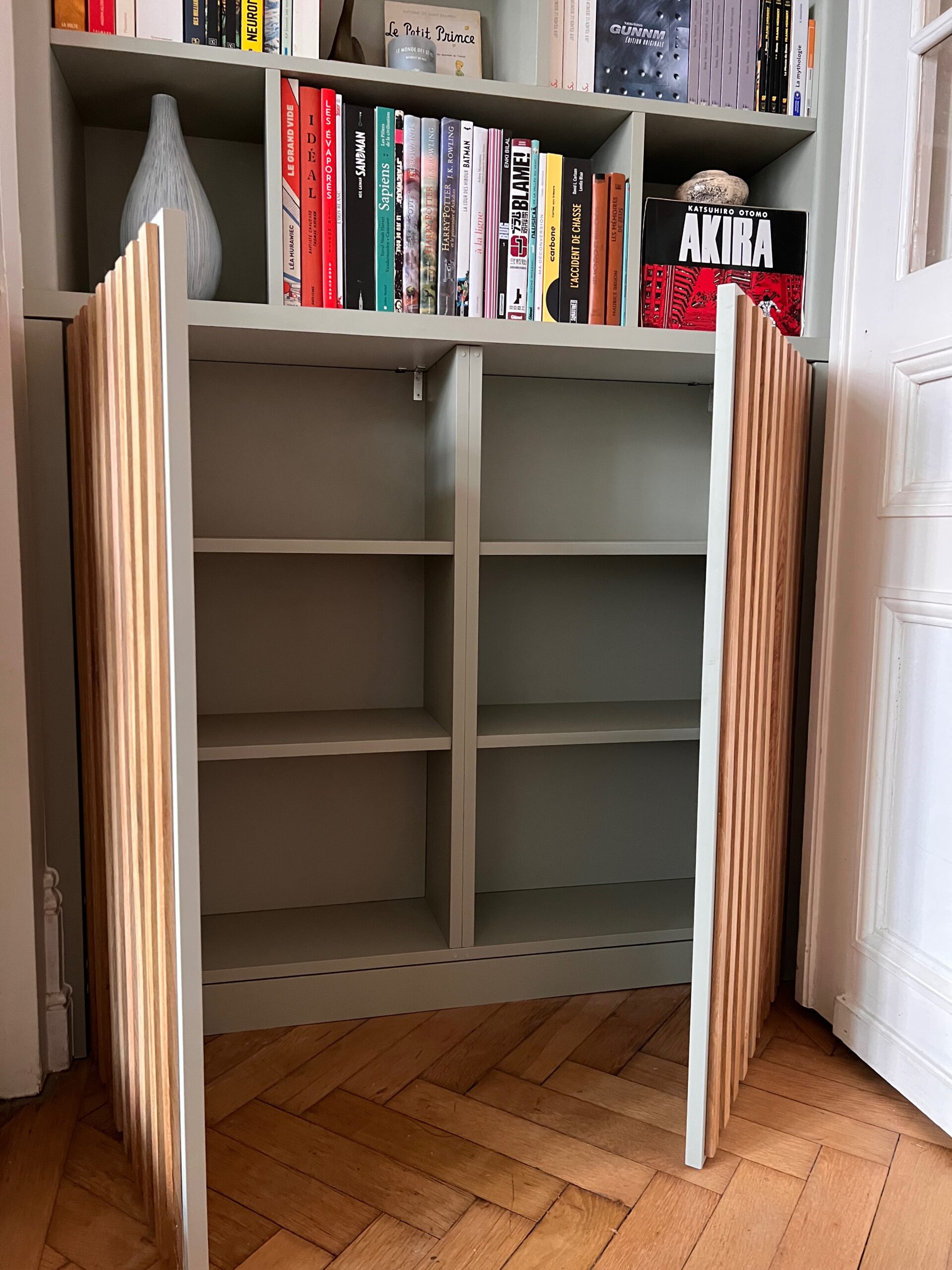 Placard intégré à une bibliothèque sur mesure avec portes à lames verticales style claustra